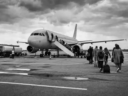Schwarzweiß-Reportage zeigt Passagiere beim Boarding eines Flugzeugs, easyJet plc, ISIN GB00B7KR2P84, Low-Cost-Airline-Betrieb - Foto: THN