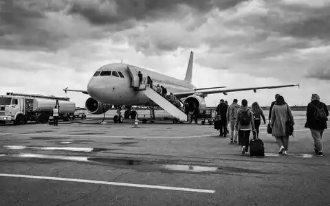 Schwarzweiß-Reportage zeigt Passagiere beim Boarding eines Flugzeugs, easyJet plc, ISIN GB00B7KR2P84, Low-Cost-Airline-Betrieb - Foto: THN