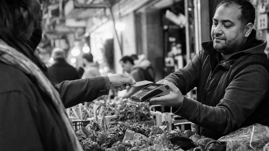 Kontaktlose Kartenzahlung am Marktstand, dokumentarisches Schwarzweiß, Global Payments US37940X1028