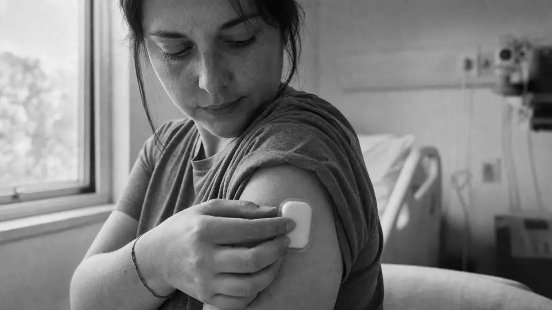 Schwarzweiß-Reportage Insulet – Patientin befestigt tubeless Insulin-Pod am Oberarm im Krankenhaus