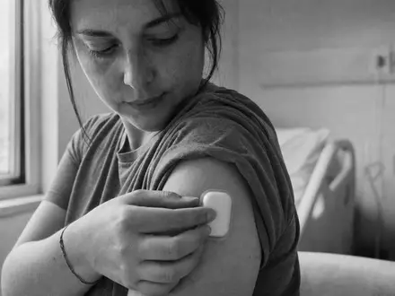 Insulet Dokumentarfoto schwarz-weiĂ: Patientin befestigt Insulin-Pod am Arm in Klinik, US45784P1012 Medizintechnik - Foto: THN