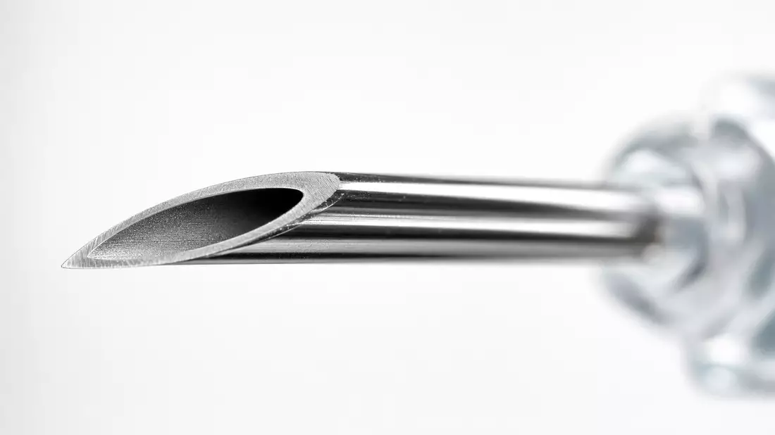 Extreme Makro-Nahaufnahme einer chirurgischen Nadel mit Metallglanz und Tiefenschärfe