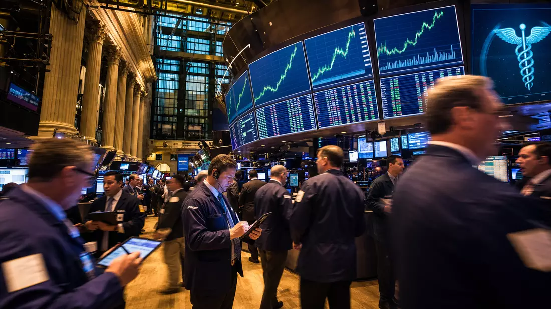 Redaktionelles Foto des NYSE-Handelsparkett mit Healthcare-Kursdiagrammen auf Großleinwänden