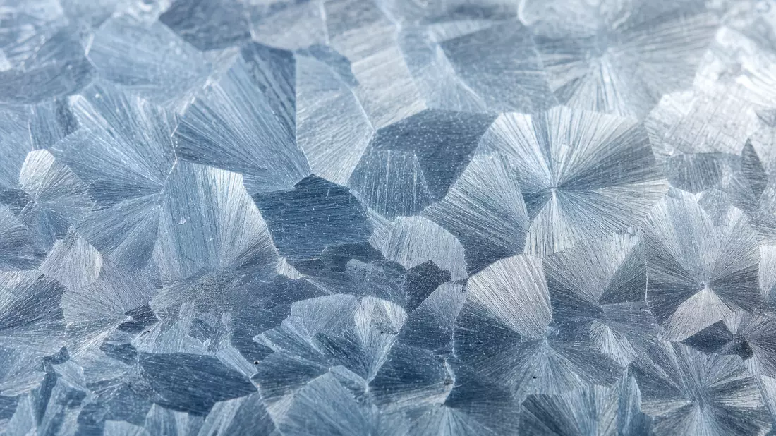 Extreme Makroaufnahme von Zink-Spangles-Kristallmuster auf galvanisierter Metalloberfläche