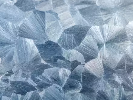 Befesa S.A. produziert Zink, dessen typische Spangles-Kristallstruktur unter dem Makroobjektiv sichtbar wird, LU1704650164 - Foto: THN