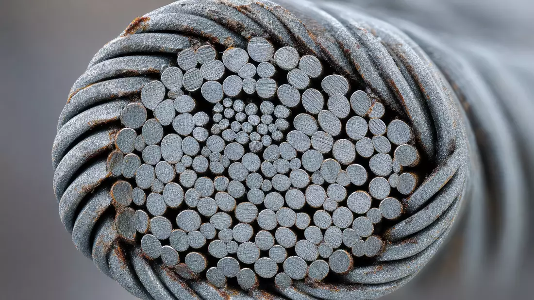Extremes Makrofoto eines Stahlkabelquerschnitts mit gewundenen Metalldrähten und Zinkbeschichtung
