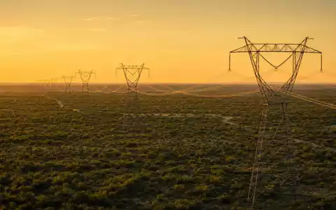 CenterPoint Energy Inc. Hochspannungsmasten bei Sonnenuntergang in der texanischen Ebene, ISIN US15189T1079 - Foto: THN