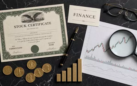 Charles Schwab Corp. US8085131050 Flatlay mit Aktien-Zertifikat ISIN-Karte Börsenwerkzeuge und Goldmünzen auf Marmor - Foto: THN