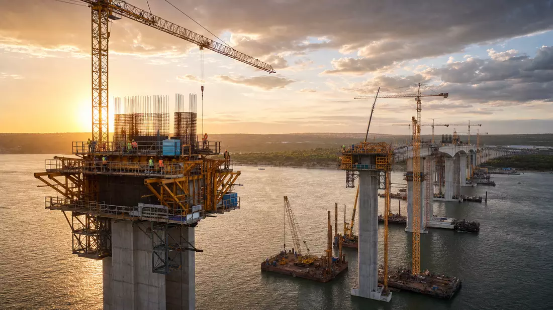 Fotorealistischer Blick auf HOCHTIEF AG Brückenbau mit Kränen im Sonnenuntergang