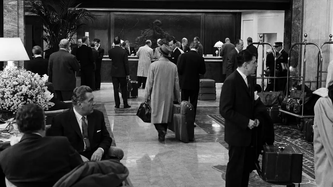 Schwarzweiß-Reportage einer belebten Hilton Worldwide Hotellobby mit Reisenden