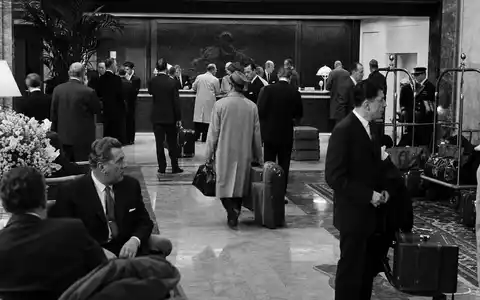 Hilton Worldwide Hotellobby in Schwarzweiß, US43300A2033, Reisende mit Gepäck an der Rezeption im Vintage Stil - Foto: THN