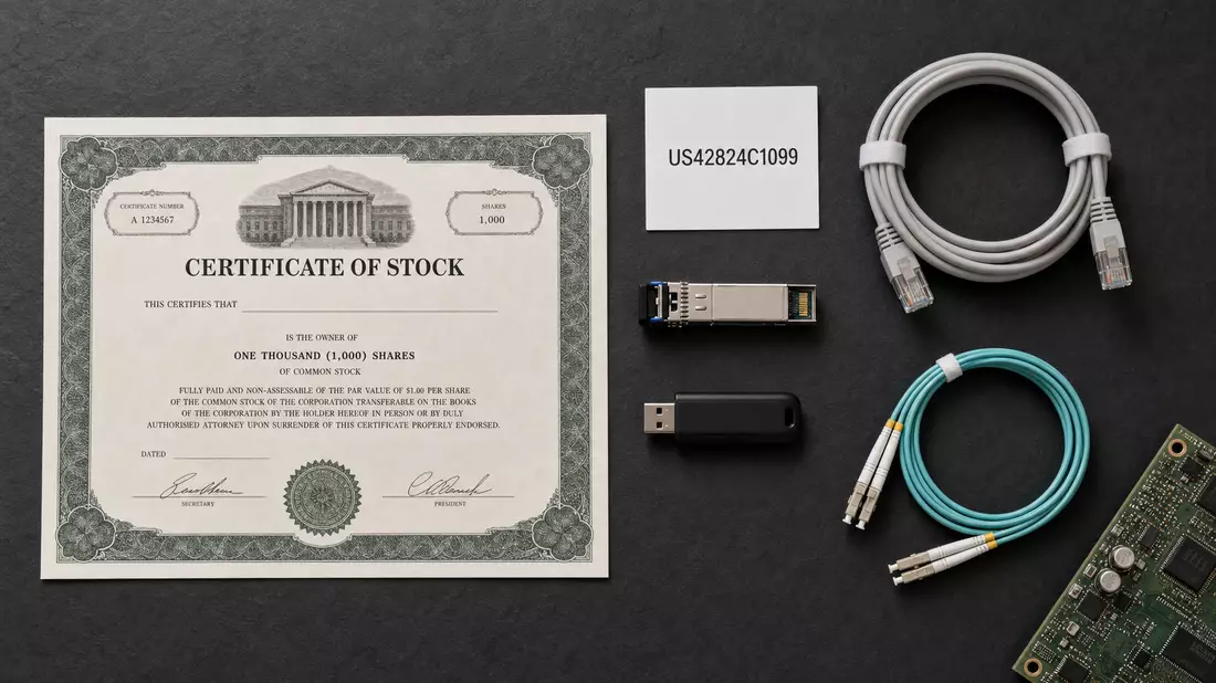 Flatlay mit Aktienzertifikat, ISIN-Karte US42824C1099 und Netzwerkkomponenten auf Schiefer