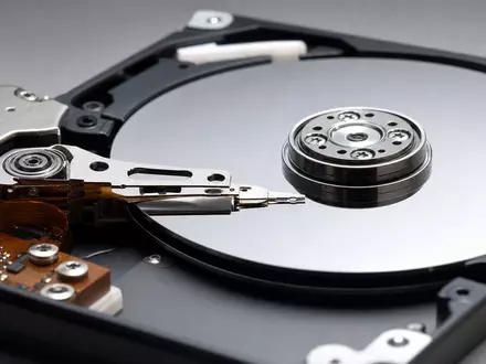 Seagate Technology (IE00B58PMW19): fotorealistische Nahaufnahme einer geöffneten Festplatte mit spiegelnden Magnetplatten und feinem Schreibkopf - Foto: THN