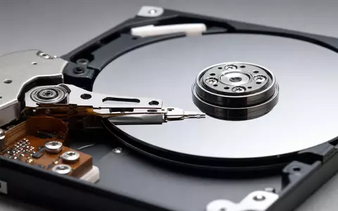 Seagate Technology (IE00B58PMW19): fotorealistische Nahaufnahme einer geöffneten Festplatte mit spiegelnden Magnetplatten und feinem Schreibkopf - Foto: THN