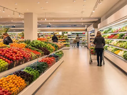 Fotorealistische Supermarkt-Frischeabteilung symbolisiert Ahold Delhaize NL0011794037 im internationalen Lebensmitteleinzelhandel mit bunten Regalen und Einkaufswagen - Foto: THN
