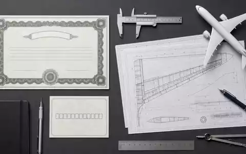 Airbus SE (NL0000235190) arrangiert ein Flatlay mit Aktienzertifikat, ISIN-Karte und Luftfahrt-Werkzeugen auf Tisch - Foto: THN