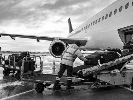 Schwarzweiß-Reportage von Gepäckverladung zeigt Bodenbetrieb der Deutsche Lufthansa AG, ISIN DE0008232125, am Flughafen - Foto: THN
