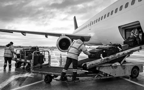 Schwarzweiß-Reportage von Gepäckverladung zeigt Bodenbetrieb der Deutsche Lufthansa AG, ISIN DE0008232125, am Flughafen - Foto: THN