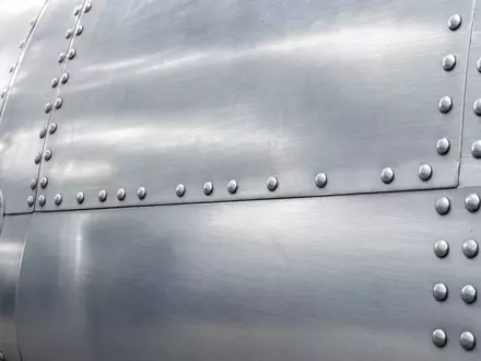Makroaufnahme einer Flugzeug-Aluminiumhaut zeigt Materialdetails im Kontext der Deutsche Lufthansa AG, ISIN DE0008232125, Flotte - Foto: THN