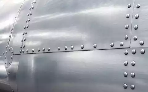 Makroaufnahme einer Flugzeug-Aluminiumhaut zeigt Materialdetails im Kontext der Deutsche Lufthansa AG, ISIN DE0008232125, Flotte - Foto: THN