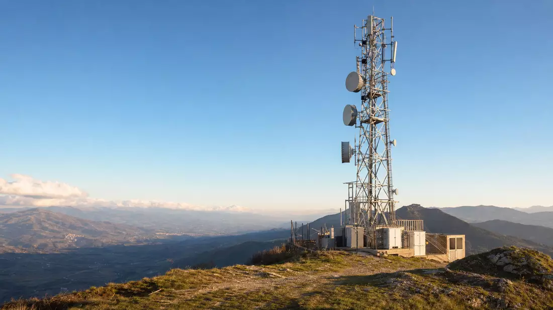 Realistischer Funkmast mit Antennen auf einem Hügel in Italien bei Sonnenuntergang