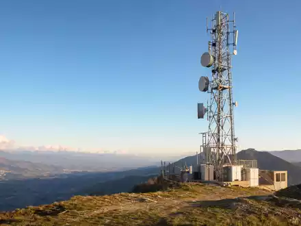 Infrastrutture Wireless Italiane S.p.A. (IT0005090300) betreibt Funkmasten, gezeigt als Sendeturm auf italienischem Hügel bei Sonnenuntergang - Foto: THN
