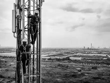 Infrastrutture Wireless Italiane S.p.A. (IT0005090300) sichert Netzinfrastruktur, hier Techniker beim Klettern am Sendemast, Schwarzweiß-Reportage - Foto: THN