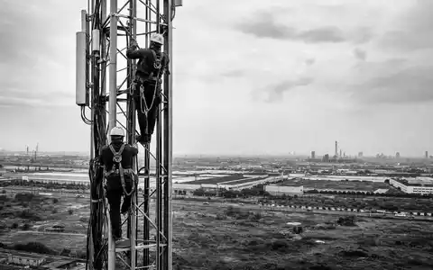 Infrastrutture Wireless Italiane S.p.A. (IT0005090300) sichert Netzinfrastruktur, hier Techniker beim Klettern am Sendemast, Schwarzweiß-Reportage - Foto: THN