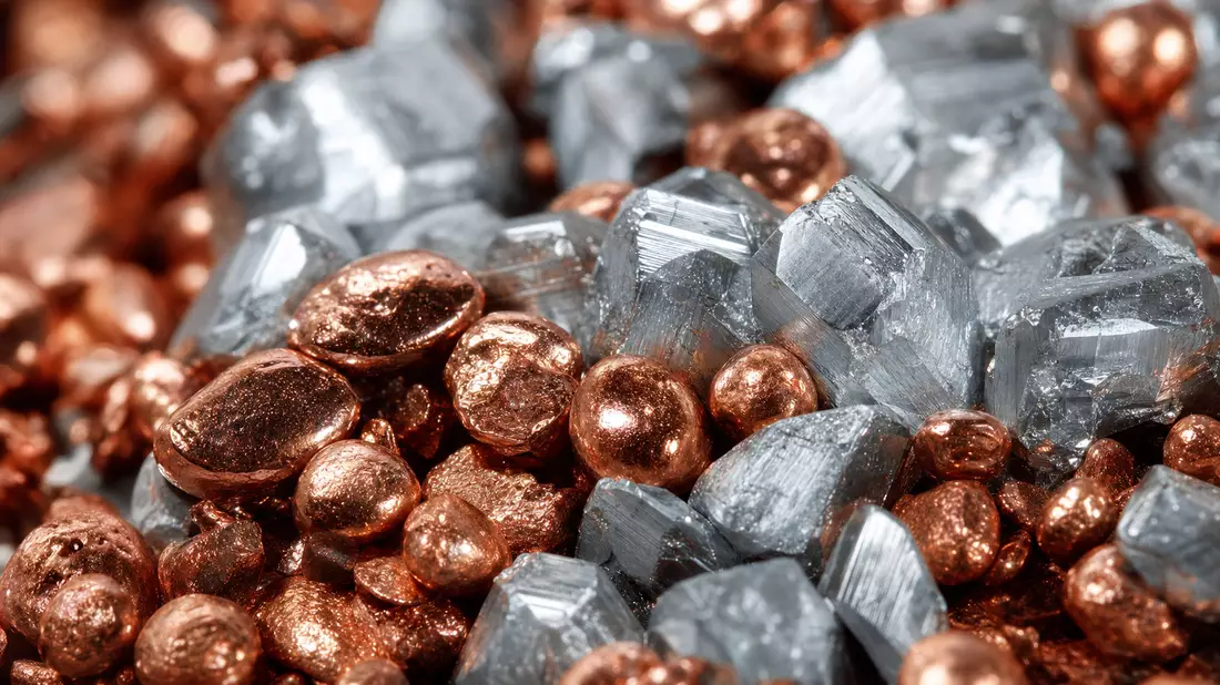 Makroaufnahme glänzender Kupfergranulate und silbriger Metallkristalle in Nahaufnahme