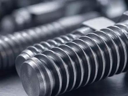 Illinois Tool Works US4523081093 Makroaufnahme von präzisionsgefertigten Stahlschrauben mit scharfen Gewindedetails und Metallstruktur - Foto: THN