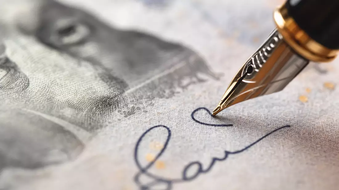 Extreme Nahaufnahme einer Banknote mit Füllfederhalter beim Unterschreiben eines Dokuments