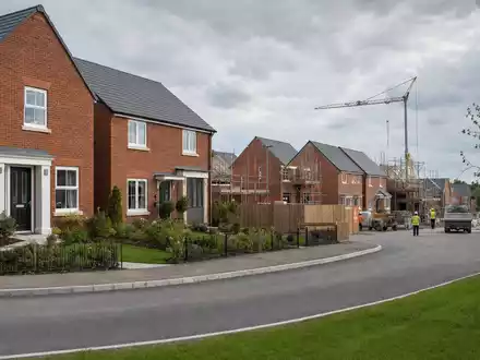 Fotorealistische Neubausiedlung mit Kran zeigt Taylor Wimpey plc, den Wohnungsbau-Entwickler mit ISIN GB0008782301, symbolisch - Foto: THN