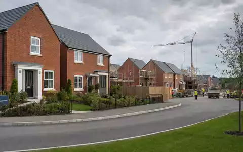 Fotorealistische Neubausiedlung mit Kran zeigt Taylor Wimpey plc, den Wohnungsbau-Entwickler mit ISIN GB0008782301, symbolisch - Foto: THN