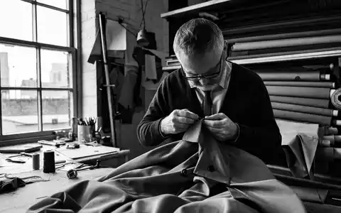 Dokumentarische Schwarzweiß-Reportage zeigt Handarbeit für Burberry Group plc, ISIN GB0031743007, in traditioneller Näherei London - Foto: THN