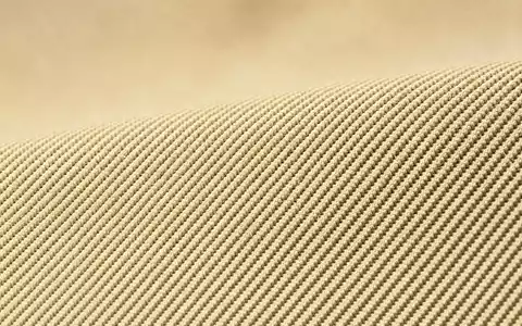 Makroaufnahme eines neutralen Stoffgewebes veranschaulicht Materialqualität von Burberry Group plc, ISIN GB0031743007, ohne charakteristisches Karomuster - Foto: THN