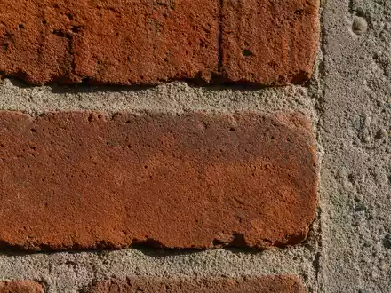 Makroaufnahme von Backstein und Beton zeigt Baumaterial von Persimmon plc GB0030927254 im Detail sehr nah - Foto: THN