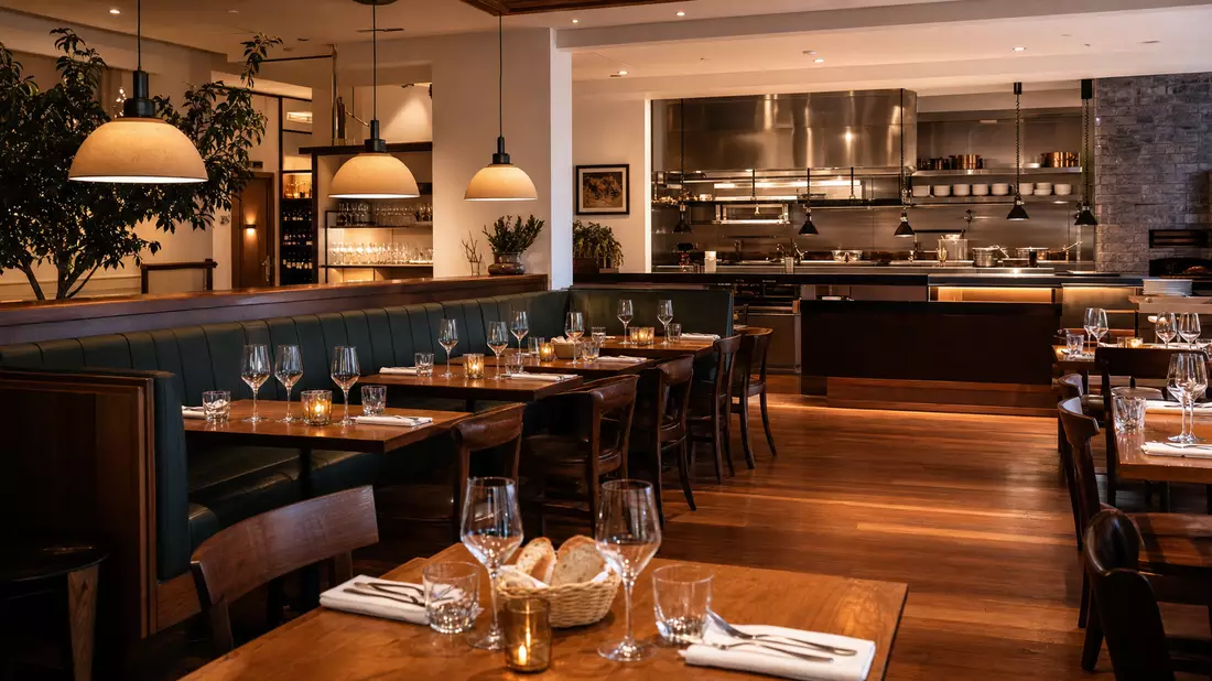 Fotorealistisches Restaurantinterieur mit gedeckten Tischen und offenem Küchenbereich