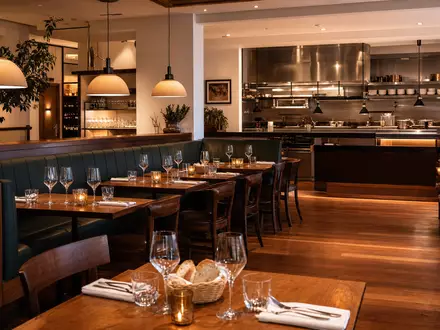 Darden Restaurants US2371941053 zeigt warmes Casual-Dining-Interieur mit Holztischen, Weingläsern und offener Küche - Foto: THN