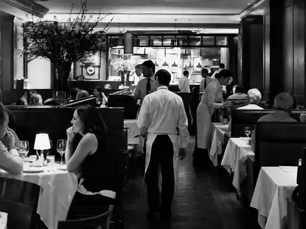 Darden Restaurants US2371941053 dokumentarisch in Schwarzweiß: belebter Speisesaal mit Servicepersonal und Gästen - Foto: THN