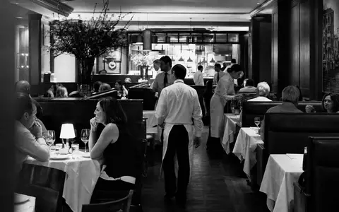 Darden Restaurants US2371941053 dokumentarisch in Schwarzweiß: belebter Speisesaal mit Servicepersonal und Gästen - Foto: THN