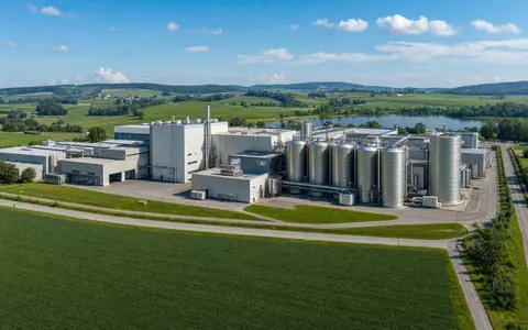 Danone S.A. Milchverarbeitungswerk FR0000120644 in europäischer Agrarlandschaft mit großen Silos und grünen Feldern - Foto: THN