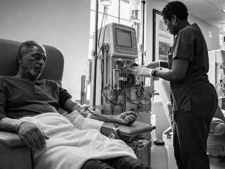Dokumentarische Schwarzweiß-Aufnahme eines Dialysepatienten der DaVita Inc. mit Pflegekraft beim Behandeln, ISIN US23918K1088 - Foto: THN