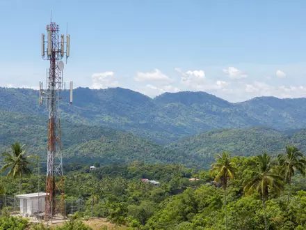 Millicom International Cellular SE0001174970 zeigt Mobilfunkantenne in tropischer Landschaft Lateinamerikas realistisch dargestellt - Foto: THN
