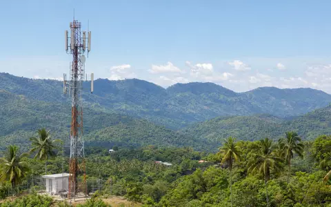 Millicom International Cellular SE0001174970 zeigt Mobilfunkantenne in tropischer Landschaft Lateinamerikas realistisch dargestellt - Foto: THN