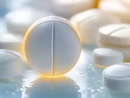 IQVIA Holdings Branchenprodukt US46266C1053 als extreme Makrofotografie weißer Pharmatabletten mit warmem Gegenlicht und Bokeh - Foto: THN