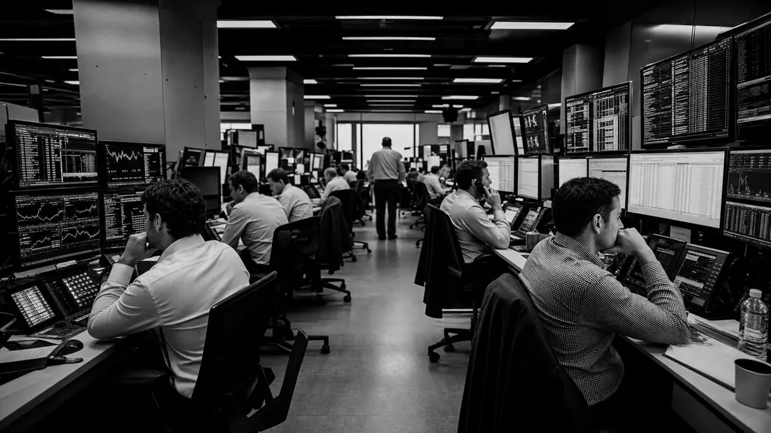 Schwarzweiß-Reportagefoto eines Invesco Ltd. Handelsraums mit Analysten an Monitoren