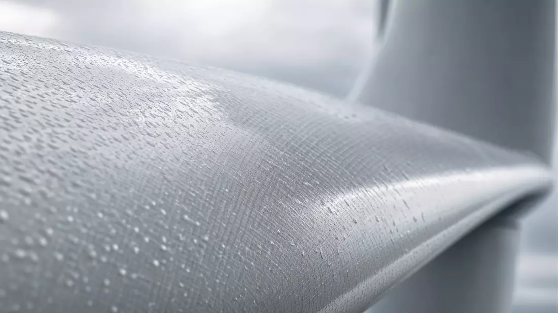 Makroaufnahme der Oberfläche eines Windturbinenblatts mit Regentropfen und Textur