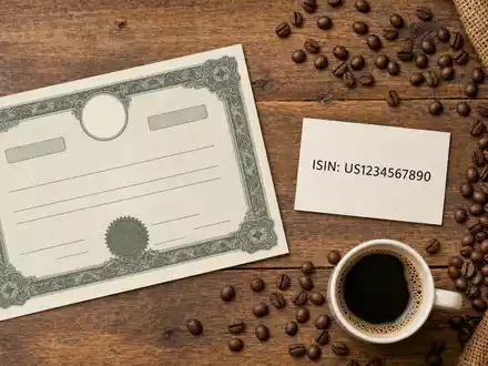 Flatlay mit Aktienzertifikat und Kaffeebohnen veranschaulicht Investment in JDE Peet's N.V., ISIN NL0014332678, Kapitalmarktbezug - Foto: THN