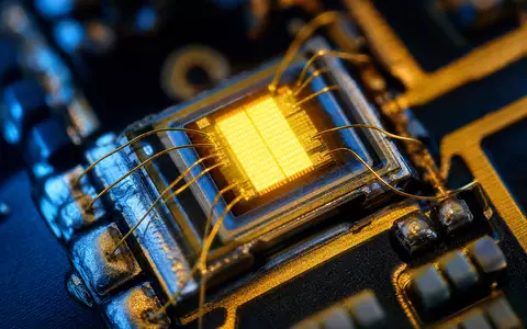 Signify N.V. mit ISIN NL0012866412 zeigt in Makroaufnahme einen leuchtenden LED-Chip mit feinen goldenen Drahtverbindungen - Foto: THN