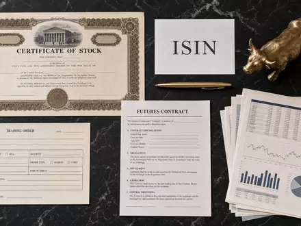 CME Group Inc. Flatlay mit Aktienzertifikat und ISIN-Karte, US12572Q1058 inmitten von Finanzinstrumenten arrangiert - Foto: THN
